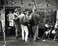 404540 Afbeelding van enkele jongens die uit de muur eten bij een snackbar aan de Bakkerstraat te Utrecht.